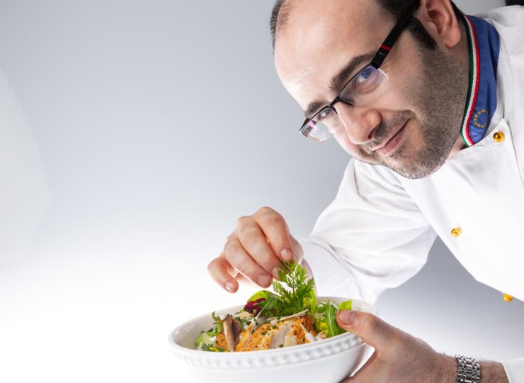Chef holding a bowl with salad in